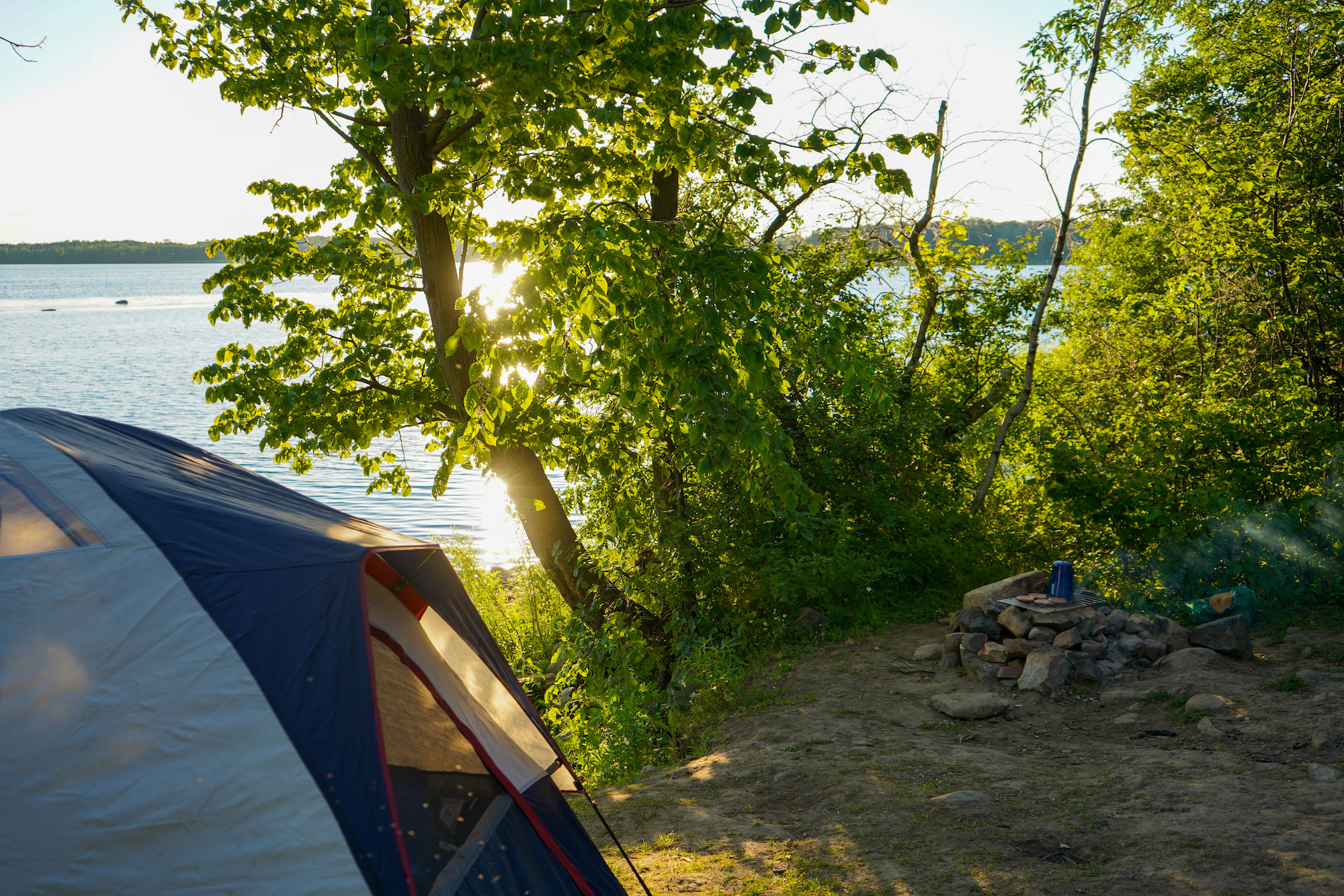 Campsite waterfront view during golden hour.